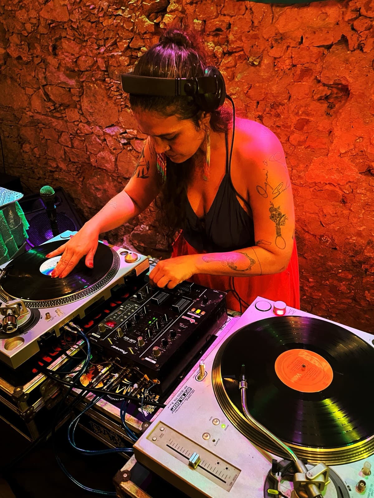 Tha Redig mixando vinil sob luz roxa