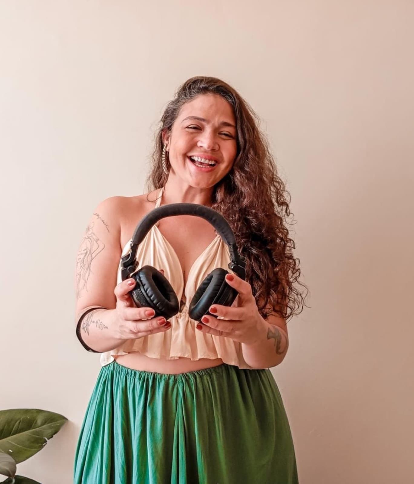 Tha Redig sorrindo com fones de ouvido nas mãos